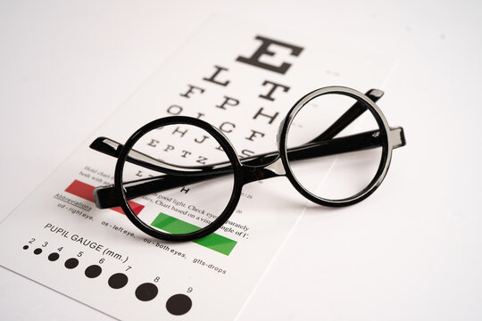 Glasses on eye testing exam chart to check eyesight accuracy of reading.