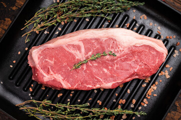 Fresh strip loin beef steak, striploin steak on a grill pan wooden background. top view