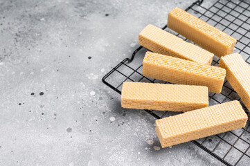Dry Wafer stick biscuits with vanilla cream on a rack. grey background. top view