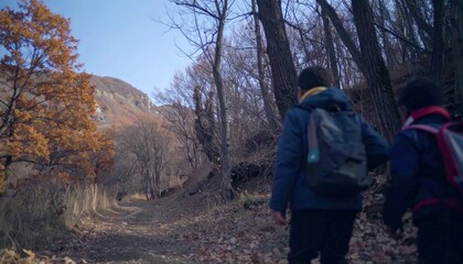 Two children are walking through a forest with backpacks. Scene is peaceful and serene, as the children are surrounded by nature and the trees are bare