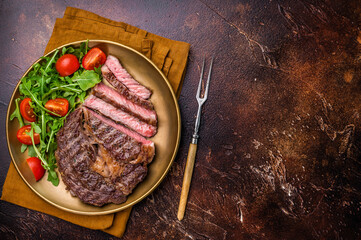 Dinner with Grilled Rib eye steak, fried dry aged beef meat. brown background. top view