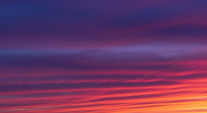 A vibrant sunset with streaky purple and pink clouds.