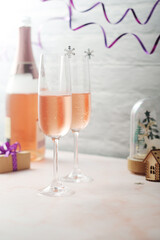 Two glasses and a bottle with pink champagne, New Year eve