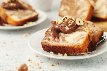 A piece of marble biscuit with chocolate cream and nuts