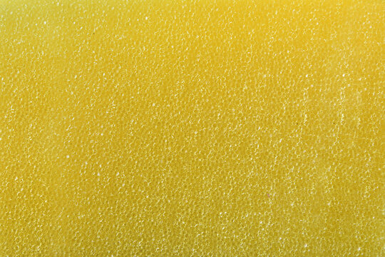 Detail of texture of synthetic yellow sponge with tiny holes
