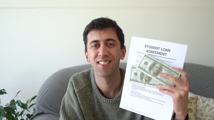 Man showing his student loan agreement and the cash he got with it. Concept of getting in debt to go to college.