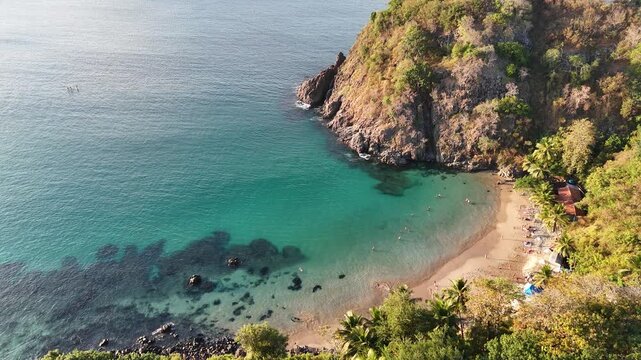 Drone aerial view of Praia do Cachorro beach in Fernando de Noronha, Brazil, showing turquoise waters, sand, and tropical island paradise