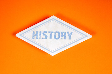 History concept on white label against orange background with bold blue typography