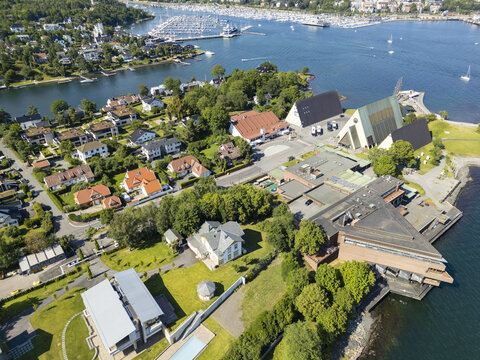 Aerial view of the striking architecture of the Henie Onstad Art Centre, blending with the serene coastline, lush greenery, and the distant boats bobbing in the harbor, Oslo, Oslo, Norway.