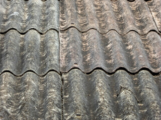 Close-up of weathered gray wavy rooftop shingles.