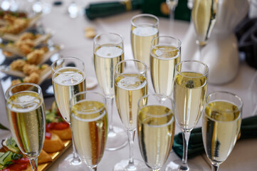 glasses of champagne on a white table in a banquet hall.
