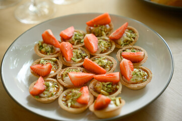 mini canapes with cheese and strawberries on a plate