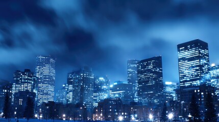 Nighttime cityscape showcasing illuminated skyscrapers against a moody blue sky with clouds
