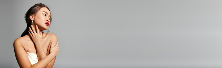 Elegant bride in a stunning white wedding dress poses gracefully in studio light