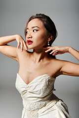 Fototapeta premium Captivating young bride in elegant white dress poses gracefully in studio setting