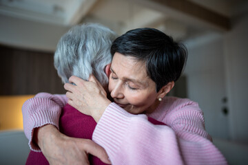 Trust and support in retired couple. Calm happy senior wife hugs husband with love, woman gives...