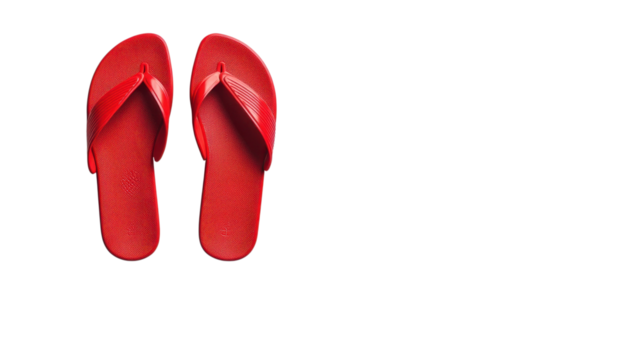 Classic red flip flops rest on a clean white surface, embodying summer warmth and relaxed outdoor activities
