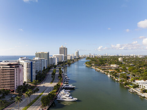 Aerial view of the Intracoastal Waterway reflecting the blue sky as luxury yachts line the shore of Indian Creek near Collins Avenue, Miami Beach, Florida, United States.