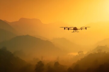 Silhouette of drone flying over misty mountains at sunset.
