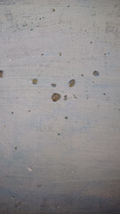 Concrete slab with various small holes and surface imperfections in a work area