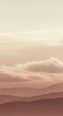 Obraz premium Layered mountain ranges fade into soft clouds under a pale sky, creating a serene and tranquil natural landscape at dawn