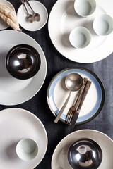 Top view of an empty plates, bowls, glasses and cutlery placed on a black chalkboard background. Flat lay. Top view. Food concept.