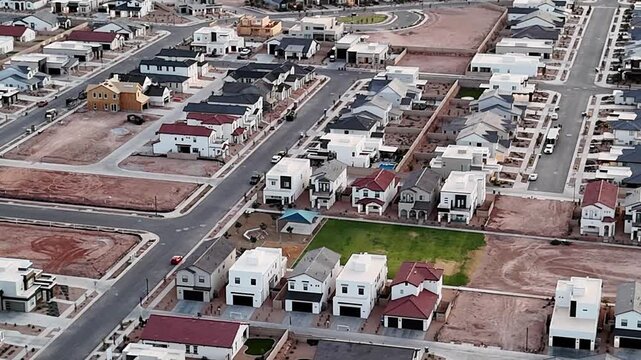 A newly built subdivision with rows of houses and empty lots, connected by paved roads.