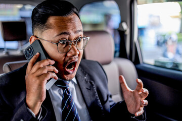 Shocked Businessman In Car Yelling On Phone, Eyes Wide Open In Disbelief