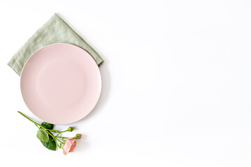 Stylish table setting with empty plate and napkin - flowers decorated on white background, top view, flat lay