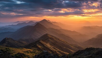 Mountain vista at sunset.  Golden light bathes rugged peaks and hazy valleys