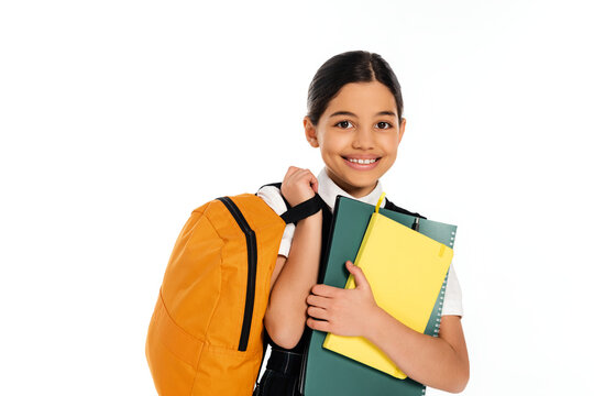 Joyful preteen schoolgirl prepares for back to school with colorful supplies in studio