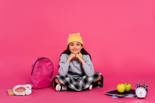 Stylish preteen girl prepares for school amidst vibrant pink studio background - Powered by Adobe