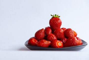 Juicy seasonal strawberries close up macro texture on a black plate