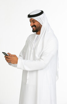 Portrait of an emirati man on a white background using mobile.