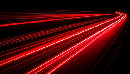 Long exposure of red light trails curving against a black background,