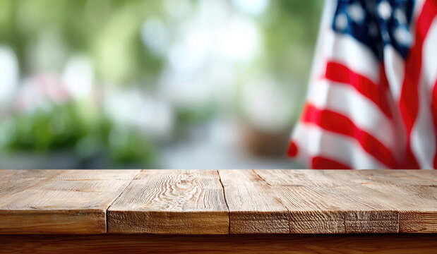 Empty wooden table with blurred American flag in background, evoking patriotic themes, celebrations, or product display in a natural outdoor setting. Copy space.