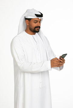 Portrait of an emirati man on a white background using mobile.