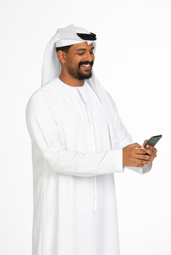 Portrait of an emirati man on a white background using mobile.