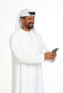 Portrait of an emirati man on a white background using mobile.