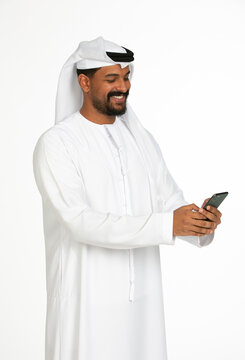 Portrait of an emirati man on a white background using mobile.