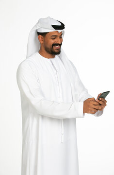 Portrait of an emirati man on a white background using mobile.