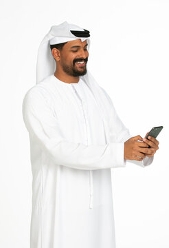 Portrait of an emirati man on a white background using mobile.