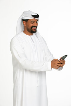 Portrait of an emirati man on a white background using mobile.