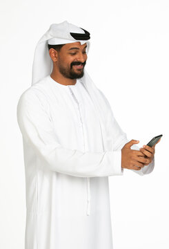 Portrait of an emirati man on a white background using mobile.
