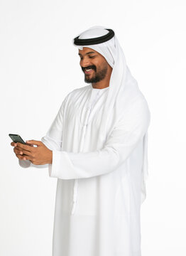 Portrait of an emirati man on a white background using mobile.