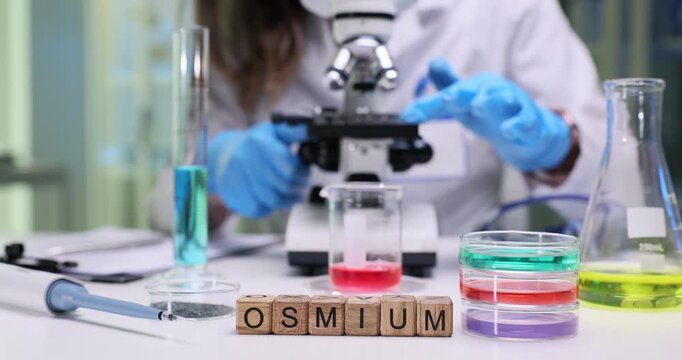 A dedicated researcher conducts experiments on osmium using advanced lab equipment and a microscope