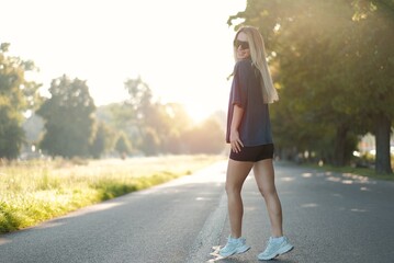 Stylish Fit Blonde Woman In Black Sunglasses Enjoying Outdoor Walk on a Sunny Day