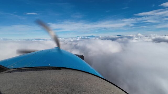 POV small airplane flying above the clouds, aircraft nose and propeller
