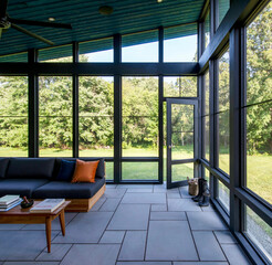 Sunroom with dark framed windows and blue ceiling overlooking green trees interior architecture
