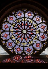 Intricate stained glass rose window casting vibrant reflections on the surface below